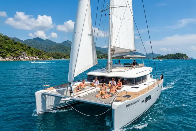 Large sailing catamaran under full sail with guests on the trampoline nets near Koh Samui