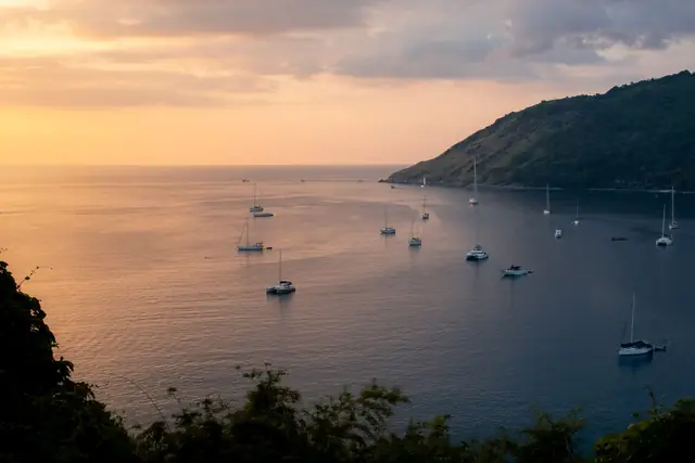 Sailing yachts anchored in a bay at sunset