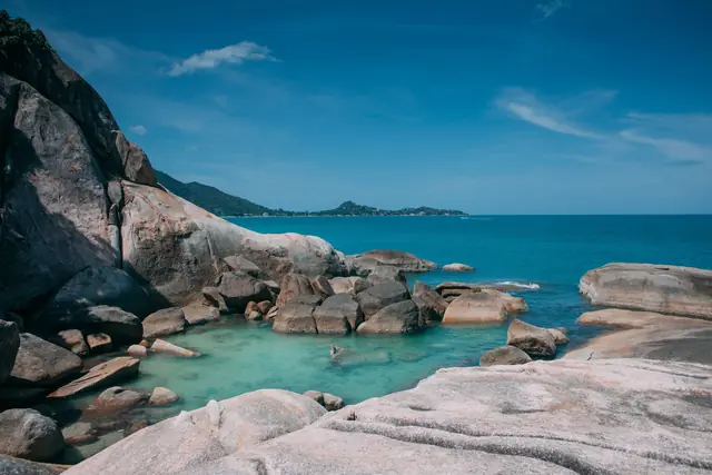 A clear rock pool among smooth granite boulders on the Koh Samui shoreline