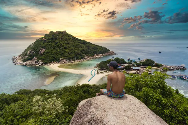 A traveller on the viewpoint rock above the sandbar of Koh Nang Yuan