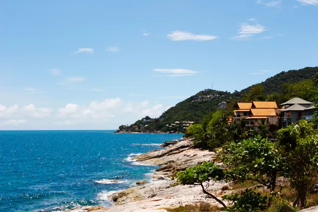 Toits thaïs sur un promontoire rocheux au-dessus d’une mer d’un bleu profond, Koh Samui