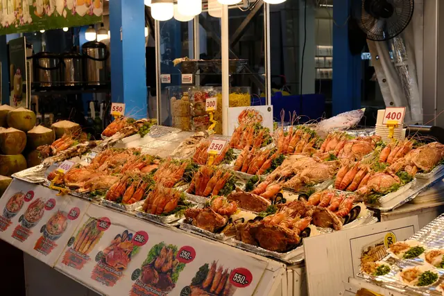 Prawns and fish laid out on ice at a night market seafood stall