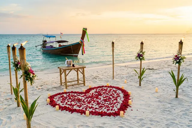 Marriage proposal set-up with rose petals and torches on a Koh Samui beach