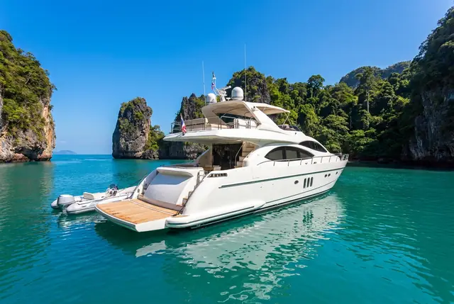 White luxury motor yacht anchored in a turquoise bay near Koh Samui